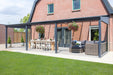 Deponti Pigato Aluminium Pergola Veranda Grey - Front Side View with Dining Table and Sofa Set in Front of the House